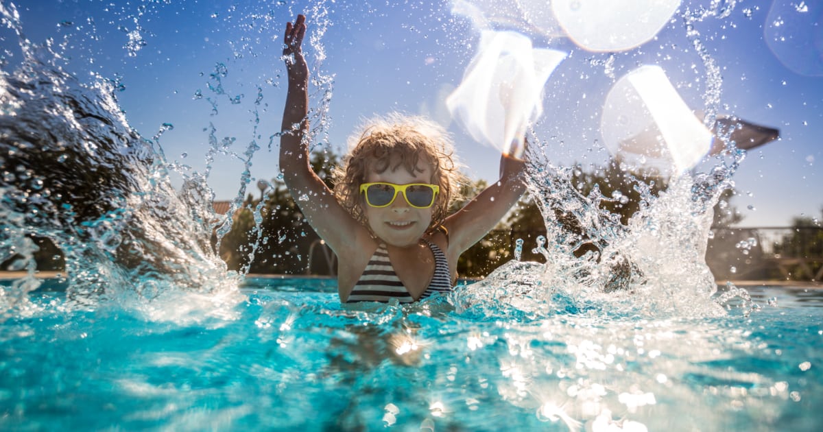 Happy child playing in swimming pool.